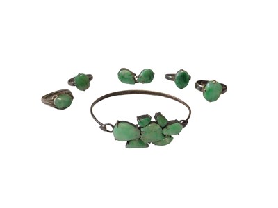 Lot 8 - Chinese silver bangle mounted with seven green jade/ hard stone panels, together with four Chinese silver and green jade/ hard stone rings and a similar pair of earrings