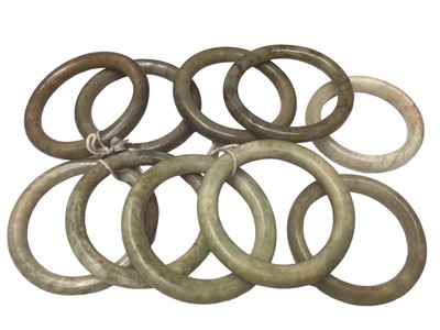 Lot 14 - Ten green jade/ hard stone polished bangles, 7cm- 8cm diameter