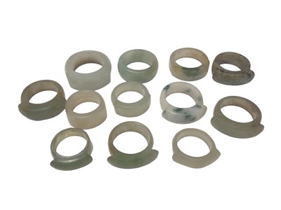 Lot 17 - Collection of twelve Chinese polished green hard stone/ jade rings