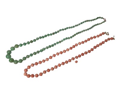 Lot 1091 - Green jade/ hard stone graduated bead necklace and an angel skin coral bead necklace (2)
