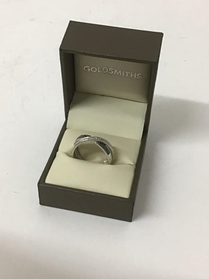 Lot 33 - White and black diamond ring with a triple band in a cross-over design in 9ct white gold, estimated total diamond weight approximately 0.25cts, purchased from Goldsmiths, boxed.