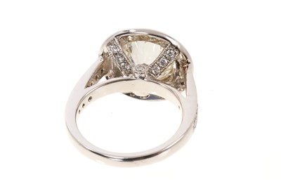 Lot 692 - Fine diamond single stone ring, the round brilliant cut diamond weighing 3.38 carats, in a rub-over setting, surrounded by a border of twenty-five brilliant cut diamonds with fourteen diamonds to t...