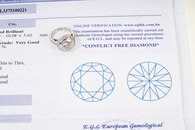Lot 692 - Fine diamond single stone ring, the round brilliant cut diamond weighing 3.38 carats, in a rub-over setting, surrounded by a border of twenty-five brilliant cut diamonds with fourteen diamonds to t...