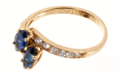 Lot 739 - Cartier sapphire and diamond cross-over ring with two marquise cut blue sapphires in a cross-over design with graduated brilliant cut diamonds to the shoulders on 18ct yellow gold shank, signed Car...
