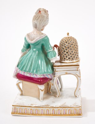 Lot 327 - A 19th century Meissen lace figure of a lady feeding her pet parrot, polychrome decorated, crossed swords mark with incised model number 'E4', 14.5cm high