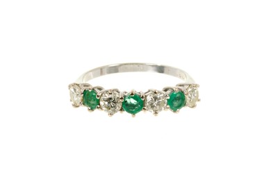 Lot 540 - Emerald and diamond eternity ring with a half hoop of three round mixed cut emeralds and three brilliant cut diamonds in 18ct white gold setting