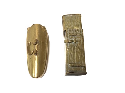 Lot 5 - Victorian brass novelty Vesta case in the form of an outside privy with opening door revealing seated figure 50mm high and another in the form of a brass violin case (2)