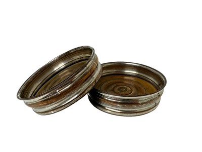 Lot 37 - Pair of Georgian Old Sheffield plate wine coasters with turned fruitwood bases, 13cm diameter