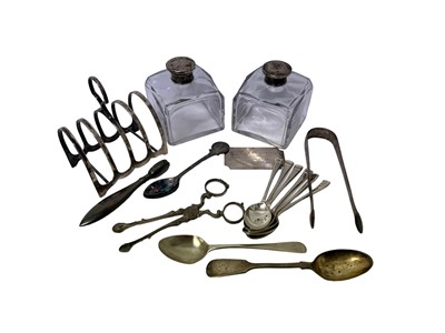 Lot 54 - Pair of Georgian silver scissor action sugar tongs, another pair of Georgian silver bright cut tongs, silver toast rack, pair of silver topped bottles and other items, weighable silver all at 8ozs