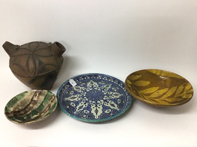 Lot 50 - Two Eastern slipware pottery dishes, possibly Afghan, together with a large ewer and an Iznik style dish (4)