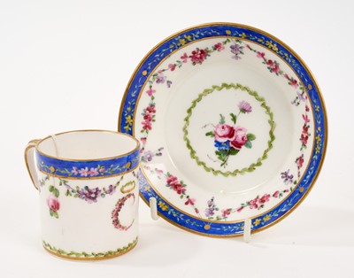 Lot 59 - Sèvres cup and saucer, polychrome decorated with floral swags on a blue ground, initial 'C' to the front of the cup, inscribed marks to base, possible date mark of 1786, the saucer 12cm diameter