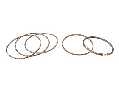 Lot 20 - 9ct three colour gold triple bangle, one other 9ct gold bangle and a yellow and white metal bangle (3)