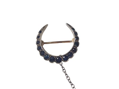 Lot 23 - Victorian sapphire crescent brooch with fifteen graduated round mixed cut blue sapphires in a yellow and white metal setting, 25mm wide