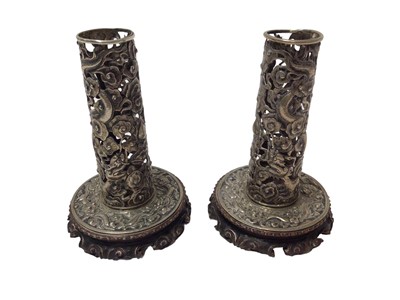 Lot 300 - Pair of Chinese white metal candlesticks with pierced dragon decoration on carved wood bases