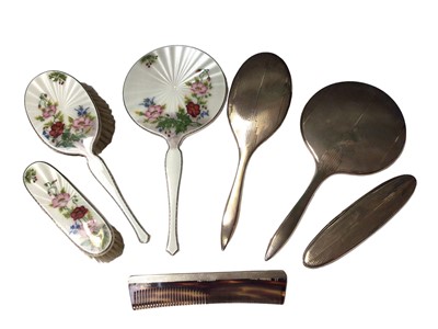Lot 79 - Silver and enamel three piece dressing table set by Garrard & Co (Birmingham 1955) with floral decoration, together with another silver set