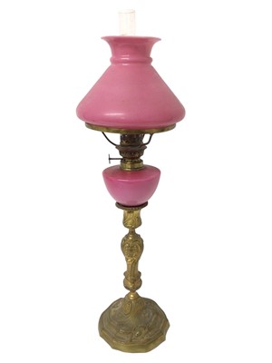 Lot 970 - 19th century peg lamp with pink glass shade and reservoir on ormolu candlestick base
