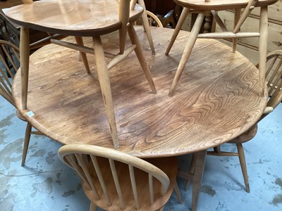 Lot 1326 - Ercol elm oval dropleaf kitchen table opening to 127 x 141cm and seven Ercol stick back chairs comprising four standards and three elbows (8)