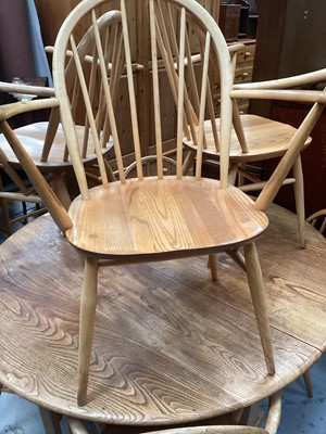 Lot 1326 - Ercol elm oval dropleaf kitchen table opening to 127 x 141cm and seven Ercol stick back chairs comprising four standards and three elbows (8)