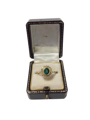 Lot 520 - Emerald and diamond cluster ring with an oval mixed cut emerald surrounded by a border of sixteen single cut diamonds in 18ct gold setting, ring size L½.