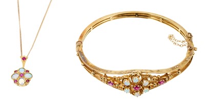 Lot 549 - Victorian style ruby and opal hinged bangle with a floral cluster and filigree design, in 9ct gold setting, together with a similar pendant on chain (2)
