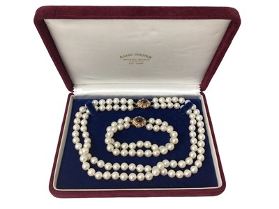 Lot 595 - Cultured pearl two strand necklace and bracelet, each with two strings of 8mm cultured pearls on a gold and garnet clasp, necklace 41cm and 19.5cm (2)