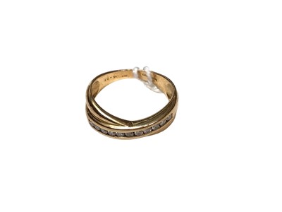 Lot 11 - 18ct gold diamond set cross over band ring with a row of eleven brilliant cut diamonds