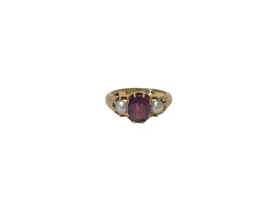 Lot 606 - Early Victorian gold garnet and pearl three stone ring, the central oval mixed cut garnet flanked by two half pearls in claw setting with engraved foliate shoulders (London 1856). Ring size N½