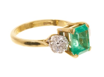 Lot 542 - Emerald and diamond three stone ring with a rectangular step cut emerald measuring approximately 8.3mm x 7mm x 5.8mm, flanked by two brilliant cut diamonds in claw setting on 18ct yellow gold shank...