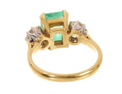 Lot 542 - Emerald and diamond three stone ring with a rectangular step cut emerald measuring approximately 8.3mm x 7mm x 5.8mm, flanked by two brilliant cut diamonds in claw setting on 18ct yellow gold shank...