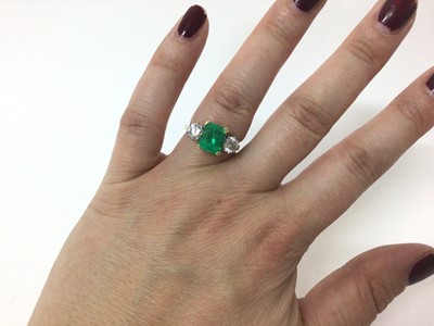 Lot 542 - Emerald and diamond three stone ring with a rectangular step cut emerald measuring approximately 8.3mm x 7mm x 5.8mm, flanked by two brilliant cut diamonds in claw setting on 18ct yellow gold shank...