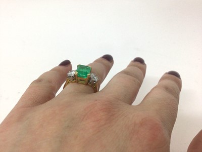 Lot 542 - Emerald and diamond three stone ring with a rectangular step cut emerald measuring approximately 8.3mm x 7mm x 5.8mm, flanked by two brilliant cut diamonds in claw setting on 18ct yellow gold shank...
