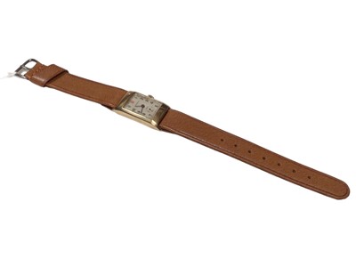 Lot 282 - 1930's 9ct gold Longines tank wristwatch with silvered dial, Arabic numeral hour markers and subsidiary seconds dial, on a brown leather strap, case approximately 20mm in diameter.