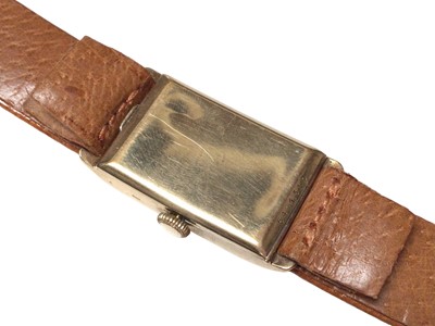 Lot 282 - 1930's 9ct gold Longines tank wristwatch with silvered dial, Arabic numeral hour markers and subsidiary seconds dial, on a brown leather strap, case approximately 20mm in diameter.