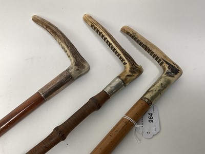 Lot 964 - Three antique hunting whips with white metal collars and bamboo shafts with antler handles