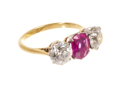 Lot 450 - Fine ruby and diamond three stone ring with an oval mixed cut ruby flanked by two old cut diamonds in platinum claw setting on 18ct gold shank