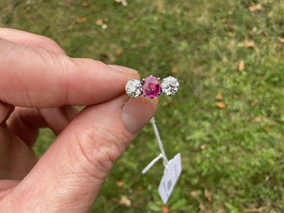 Lot 450 - Fine ruby and diamond three stone ring with an oval mixed cut ruby flanked by two old cut diamonds in platinum claw setting on 18ct gold shank