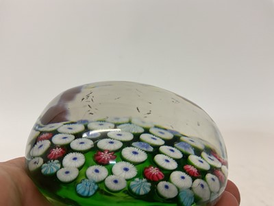 Lot 222 - 19th century French millefiori glass paperweight, with various coloured canes on a green ground