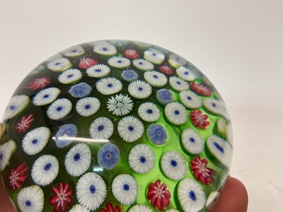 Lot 222 - 19th century French millefiori glass paperweight, with various coloured canes on a green ground