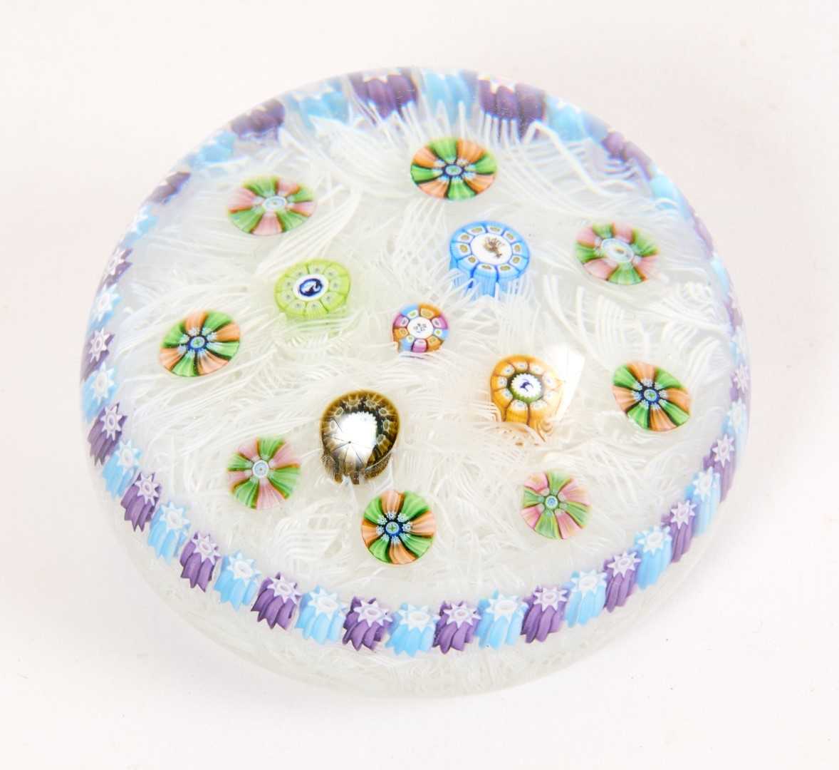 Lot 228 - Baccarat millefiori glass paperweight, decorated with canes on a latticino bed, the canes decorated with deer, a swan, a flower and a cat, the central stem possibly dated