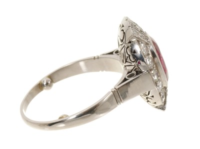 Lot 624 - Art Deco style ruby and diamond cluster cocktail ring with an oval mixed cut ruby estimated to weigh approximately 3.25cts, surrounded by ten brilliant cut diamonds estimated to weigh approximat...