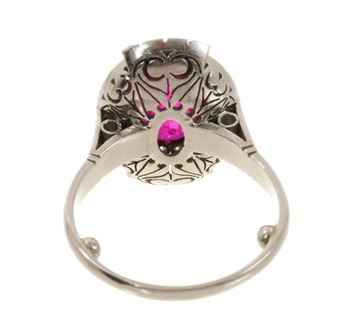 Lot 624 - Art Deco style ruby and diamond cluster cocktail ring with an oval mixed cut ruby estimated to weigh approximately 3.25cts, surrounded by ten brilliant cut diamonds estimated to weigh approximat...