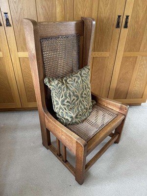 Lot 1543 - Liberty style caned oak high back chair raised on castors