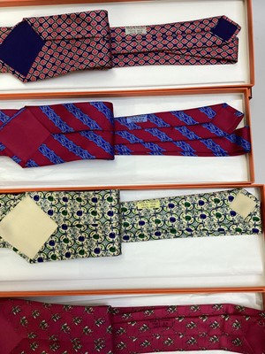 Lot 2084 - Four Hermès silk ties, Jockey riding ostrich 7987 EA, apples 7691 OA, linked horsebit 7248 MA and stylised tulip 7271 MA all in Hermes tie boxes with tissue paper.