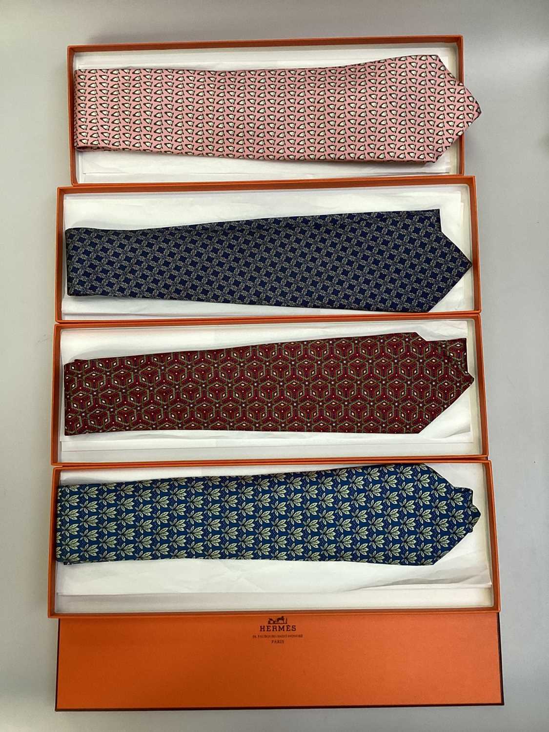 Lot 2086 - Four Hermès silk ties, leaves 7752 OA, geometric 7662 TA, penguins 5143 HA and interlinked cirles 7346 PAall in Hermes tie boxes with tissue paper