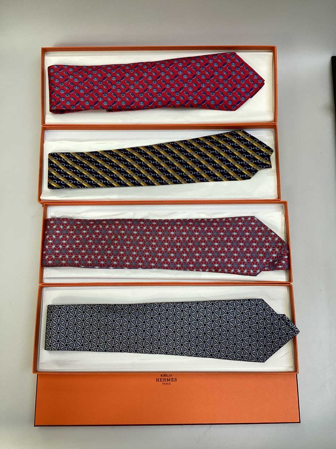 Lot 2087 - Four Hermès silk ties, floral geometric 5082 PA, horse bit with stripes 7223UA, inital H with buttons 7975 EA and interlinked circles 7633 TA, all in Hermes tie boxes with tissue paper