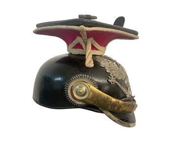 Lot 826 - Imperial German Uhlan NCO's Lance cap with black leather body, red and white piped cloth top, silvered eagle helmet plate , gilt brass chin scales and original black leather liner, Provenance...