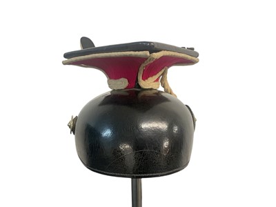 Lot 826 - Imperial German Uhlan NCO's Lance cap with black leather body, red and white piped cloth top, silvered eagle helmet plate , gilt brass chin scales and original black leather liner, Provenance...