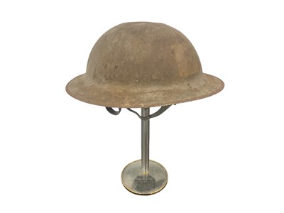 Lot 834 - First World War Mark 1 British Officers steel helmet with traces of square badges front and back, traces of liner and camouflage netting with leather chin strap, stamped numbers to rim