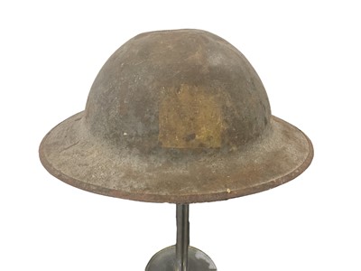 Lot 834 - First World War Mark 1 British Officers steel helmet with traces of square badges front and back, traces of liner and camouflage netting with leather chin strap, stamped numbers to rim