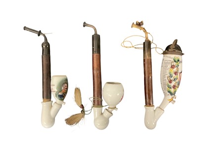 Lot 858 - Imperial German military pipe with Stummel porcelain bowl with metal pickelhaube hinged cover, painted and transfer decorated with military figure dated 1896-97 and two others (3)